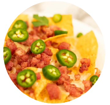 Cooked bacon crumbles and jalapenos on chips and cheese