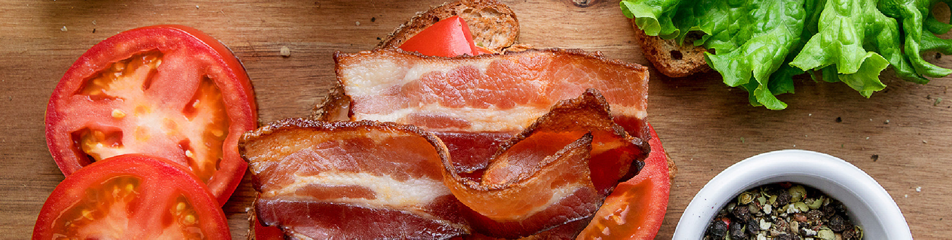 Tomatoes, bacon, lettuce, bread and spices for a sandwich